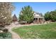 Well-maintained backyard with manicured lawn, landscaping, and view of the house with a covered patio at 5207 Denim Ct, Parker, CO 80134