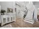Grand foyer with curved staircase, light wood floors, and elegant decor at 5207 Denim Ct, Parker, CO 80134