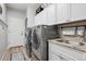 Functional laundry room featuring modern washer/dryer units and ample cabinet space at 5207 Denim Ct, Parker, CO 80134