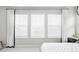 Bright bedroom featuring three large windows dressed with white drapery and shades at 500 176Th Ave, Broomfield, CO 80023