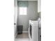 Well-lit laundry room with a window, modern washer and dryer, and neutral-toned walls and tile flooring at 500 176Th Ave, Broomfield, CO 80023