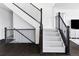 Elegant staircase features dark wood railings and trim against white walls and plush gray carpeting at 500 176Th Ave, Broomfield, CO 80023
