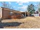 Back exterior of brick home featuring a patio, bare lawn, and mature trees at 14939 E Harvard Ave, Aurora, CO 80014