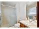 Bathroom featuring a glass door shower, vanity, and window providing natural light at 14939 E Harvard Ave, Aurora, CO 80014