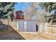 View of a metal storage shed and wooden structure in the backyard with wooden fencing at 14939 E Harvard Ave, Aurora, CO 80014