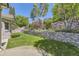Beautifully landscaped backyard with a stone retaining wall and manicured lawn at 85 Silver Fox Dr, Greenwood Village, CO 80121