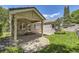View of covered patio, stone columns, and lush backyard at 85 Silver Fox Dr, Greenwood Village, CO 80121
