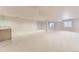 Spacious carpeted basement with a wet bar along one wall and windows at 85 Silver Fox Dr, Greenwood Village, CO 80121