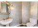 Bathroom featuring grey textured walls, a pedestal sink, and toilet with wood flooring at 85 Silver Fox Dr, Greenwood Village, CO 80121