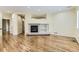 Open concept living room with hardwood floors, fireplace and built-in shelving and direct access to other rooms at 85 Silver Fox Dr, Greenwood Village, CO 80121