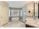 Bright main bathroom with double vanity, tub and shower, and marble floors at 85 Silver Fox Dr, Greenwood Village, CO 80121