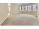 Large main bedroom featuring neutral carpet, tray ceiling, and windows with plantation shutters at 85 Silver Fox Dr, Greenwood Village, CO 80121