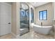 Elegant bathroom with a modern shower and a freestanding tub with a beautiful window view at 16250 Kenosha St, Brighton, CO 80603