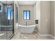 Bright bathroom featuring a modern shower, a freestanding tub, and a large window at 16250 Kenosha St, Brighton, CO 80603