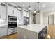 Bright kitchen with modern pendant lights, a waterfall island, stainless steel appliances, and hardwood floors at 16250 Kenosha St, Brighton, CO 80603