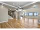 Open-concept living room with a fireplace, stairs, and large windows at 16250 Kenosha St, Brighton, CO 80603
