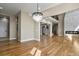 Open concept area with hardwood floors, fireplace, access to stairs and entry, and modern lighting at 16250 Kenosha St, Brighton, CO 80603