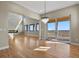 Open concept living area with fireplace feature, large windows, hardwood floors, and modern chandelier at 16250 Kenosha St, Brighton, CO 80603