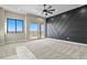 Main bedroom with carpet, ceiling fan, accent wall, and large windows with exterior views at 16250 Kenosha St, Brighton, CO 80603