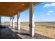 Covered patio features sturdy columns, stamped concrete flooring, and open views at 16250 Kenosha St, Brighton, CO 80603