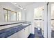 Classic bathroom with blue and white tile, a large countertop and a mirrored cabinet, and access to another bathroom at 6007 Yarrow St # I, Arvada, CO 80004