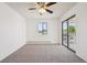 Bright bedroom featuring neutral carpeting, a ceiling fan, and a sliding glass door leading to a balcony at 6007 Yarrow St # I, Arvada, CO 80004