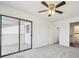 Bright bedroom with sliding glass doors to a balcony, a ceiling fan, and ensuite bathroom access at 6007 Yarrow St # I, Arvada, CO 80004