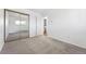 Bedroom with carpeted floors, mirrored closet, and direct access to bathroom at 6007 Yarrow St # I, Arvada, CO 80004