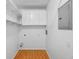 Bright laundry room with white cabinets, shelves, hookups, and light wood-look flooring at 6007 Yarrow St # I, Arvada, CO 80004