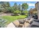 Spacious backyard with grass, stone patio and seating area perfect for outdoor entertaining at 8548 Winter Berry Dr, Castle Pines, CO 80108