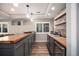 Finished basement wet bar features wood countertop, stone backsplash, and built-in beverage cooler at 8548 Winter Berry Dr, Castle Pines, CO 80108