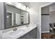 Bathroom with gray cabinets, marble countertops, and a large mirror at 8548 Winter Berry Dr, Castle Pines, CO 80108