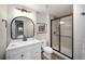 Updated bathroom with modern vanity, a large framed mirror, and a glass-enclosed shower at 8548 Winter Berry Dr, Castle Pines, CO 80108