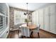 Cozy dining area with brick accent wall, a round wooden table, and natural light at 8548 Winter Berry Dr, Castle Pines, CO 80108