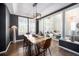 Modern dining room featuring a stylish table, contemporary lighting, dark walls, and an open view to the living room at 8548 Winter Berry Dr, Castle Pines, CO 80108