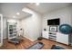 Bright exercise room with wood floors, treadmill, mounted TV and essential workout equipment at 8548 Winter Berry Dr, Castle Pines, CO 80108
