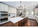 Stylish kitchen boasts quartz countertops, a large island with cooktop, and a built-in oven at 8548 Winter Berry Dr, Castle Pines, CO 80108