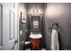 Elegant powder room featuring a pedestal sink, decorative mirror, and stylish lighting at 8548 Winter Berry Dr, Castle Pines, CO 80108