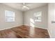 Spacious bedroom with hardwood floors, two windows, and a minimalist design, perfect for personalization at 1250 S Tennyson St, Denver, CO 80219