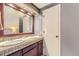 A bathroom with double sinks, a dark vanity and a tiled countertop at 14193 E Radcliff Cir, Aurora, CO 80015