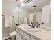 A white bathroom featuring a white sink, a mirror, and a shower with white tile at 14193 E Radcliff Cir, Aurora, CO 80015