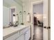 A white bathroom sink and mirror with an open door to an office space at 14193 E Radcliff Cir, Aurora, CO 80015