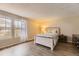 Bright bedroom featuring hardwood floors, a queen bed, and bright, natural light from the window at 14193 E Radcliff Cir, Aurora, CO 80015