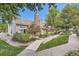 Charming townhome exterior with brick chimney, lush landscaping, and a picturesque setting at 14193 E Radcliff Cir, Aurora, CO 80015