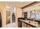 A kitchen with stainless steel appliances and a black granite countertop is near the living room and stairway at 14193 E Radcliff Cir, Aurora, CO 80015