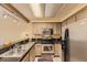 A cozy kitchen featuring stainless steel appliances and a black granite countertop at 14193 E Radcliff Cir, Aurora, CO 80015