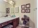 Bathroom featuring dark wood vanity, marble countertop, and framed artwork at 13908 E Linvale Pl, Aurora, CO 80014