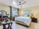 Bedroom with a large window, ceiling fan, accent wall decor, and a sitting area at 13908 E Linvale Pl, Aurora, CO 80014