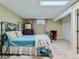 Charming bedroom with a wrought iron bed frame, skylight, and cozy decor, perfect for relaxation at 13908 E Linvale Pl, Aurora, CO 80014