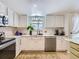 Bright kitchen with stainless steel appliances, white cabinetry, and a window with greenery at 13908 E Linvale Pl, Aurora, CO 80014